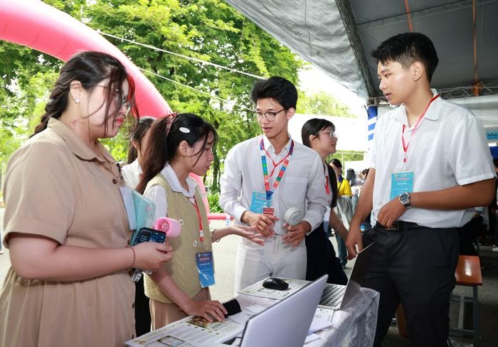 Hoàng Long (giữa) trao đổi với các bạn học về mô hình nghiên cứu của nhóm.