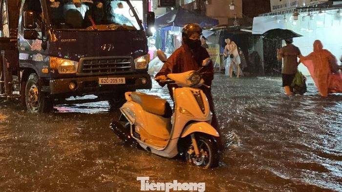 Xe "chết máy", người dân bì bõm lội nước trên đường Hồ Học Lãm. Ảnh: Hữu Huy