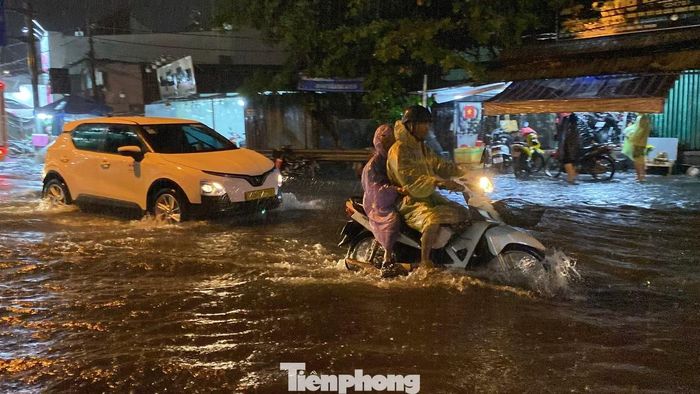 Anh Nguyễn Minh Tấn (ngụ phường An Lạc) cho biết cơn mưa kéo dài nhiều giờ khiến nước dâng nhanh hơn thường lệ. “Từ đầu mùa mưa đến nay tôi chưa thấy trận nào lớn như hôm nay. Nước ngập gần nửa bánh xe máy, nhiều người đang đi phải dừng lại vì xe chết máy”, anh nói. Ảnh: Hữu Huy
