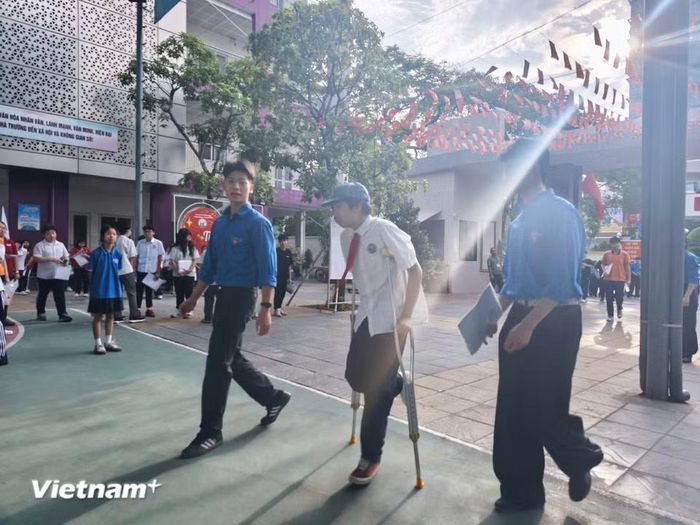 Một thí sinh phải chống nạng. Những trường hợp thí sinh đặc biệt như thế này sẽ được đội ngũ thanh niên tình nguyện hỗ trợ đưa vào bên trong điểm thi. (Ảnh: Hoài Nam/Vietnam+)