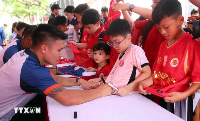 Người dân và các em nhỏ hào hứng giao lưu, xin chữ ký các cầu thủ CLB bóng đá Công an Hà Nội tại buổi lễ. (Ảnh: Phạm Kiên/TTXVN)