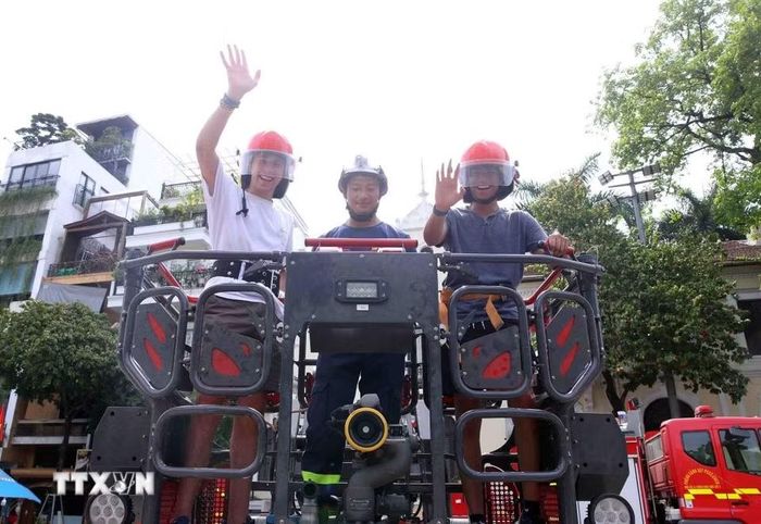 Du khách quốc tế hào hứng tham gia các hoạt động trải nghiệm phòng cháy chữa cháy và cứu nạn cứu hộ. (Ảnh: Phạm Kiên/TTXVN)