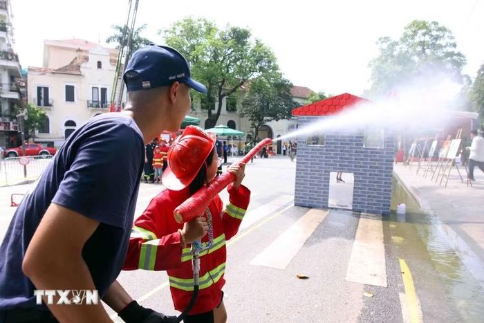 Các em nhỏ thích thú được trải nghiệm làm lính cứu hỏa. (Ảnh: Phạm Kiên/TTXVN)