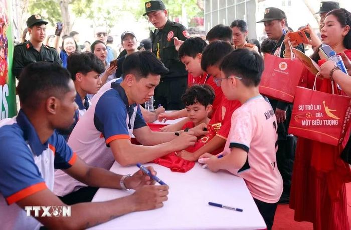 Người dân và các em nhỏ hào hứng giao lưu, xin chữ ký các cầu thủ CLB bóng đá Công an Hà Nội tại buổi lễ. (Ảnh: Phạm Kiên/TTXVN)