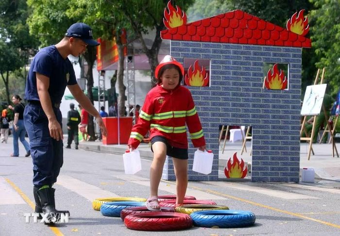 Các em nhỏ thích thú được trải nghiệm làm lính cứu hỏa. (Ảnh: Phạm Kiên/TTXVN)