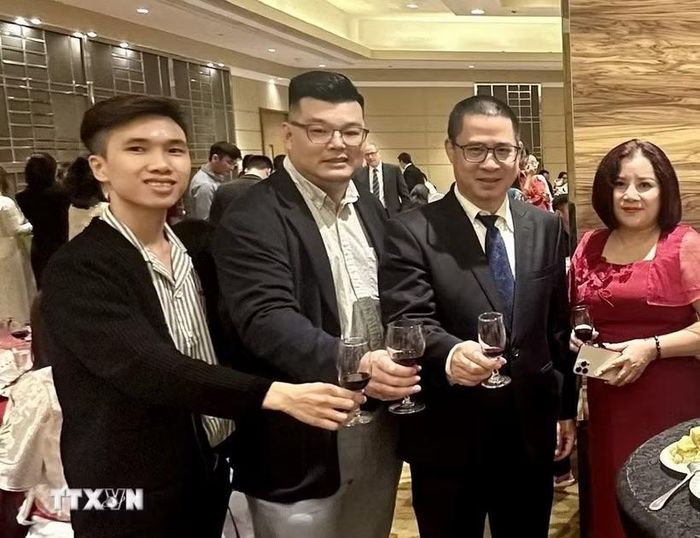 Ông Nguyễn Phạm Hoàng Nguyên (ngoài cùng, bên trái) trong sự kiện Tết cộng đồng. (Ảnh: TTXVN phát)