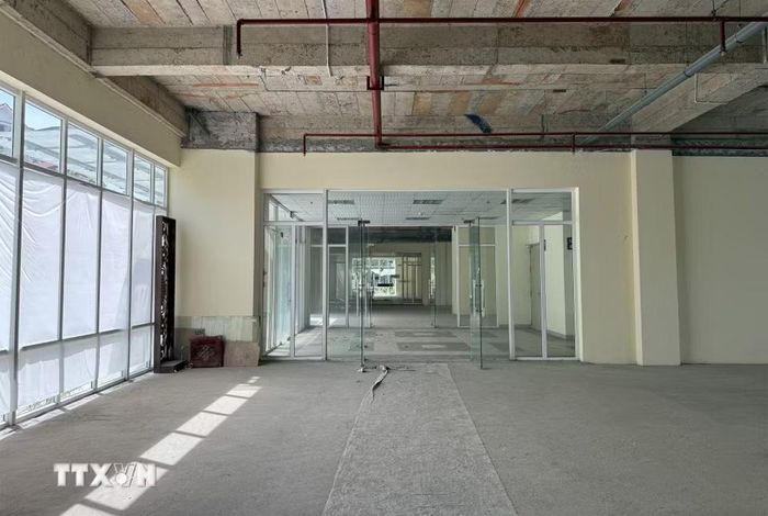 Sảnh tầng 1 của các tòa nhà vẫn đang để trống, phủ bụi, hệ thống báo cháy được lắp đầy đủ. Bên ngoài, đơn vị quản lý dán thông báo cho thuê lại mặt sàn để phục vụ kinh doanh. (Ảnh: Quốc Khánh/TTXVN)