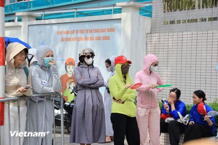 Phía sau phòng thi là hình ảnh quen thuộc của bậc phụ huynh đội nắng, kiên nhẫn chờ đợi con ngoài cổng trường. (Ảnh: Hoài Nam/Vietnam+)
