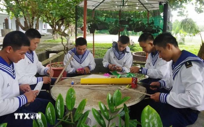 Các chiến sỹ hải quân đặc khu Trường Sa làm các đồ chơi tặng cho các cháu thiếu nhi bằng vật liệu tái chế. (Ảnh: TTXVN phát)
