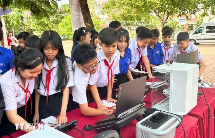 Học sinh tham gia trải nghiệm và khám phá trang thiết bị của ngành Tin học ứng dụng. (Ảnh: TTXVN phát)