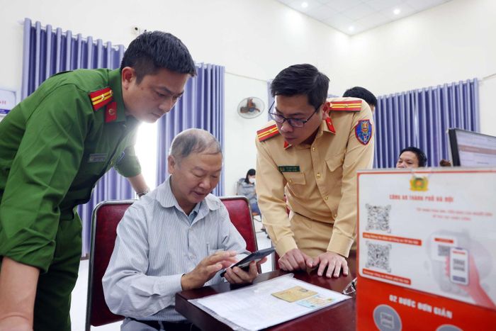 Phòng CSGT Hà Nội cử cán bộ hướng dẫn người dân thực hiện làm sạch dữ liệu đăng ký phương tiện, giấy phép lái xe. Ảnh: Phạm Kiên/TTXVN
