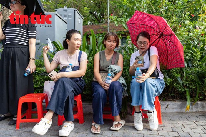 Phụ huynh đợi thí sinh làm bài thi tại điểm thi Trường trung học cơ sở Chu Văn An.