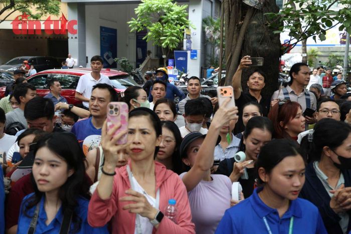 Phụ huynh tranh thủ ghi lại khoảnh khắc con em mình rời khỏi điểm thi.