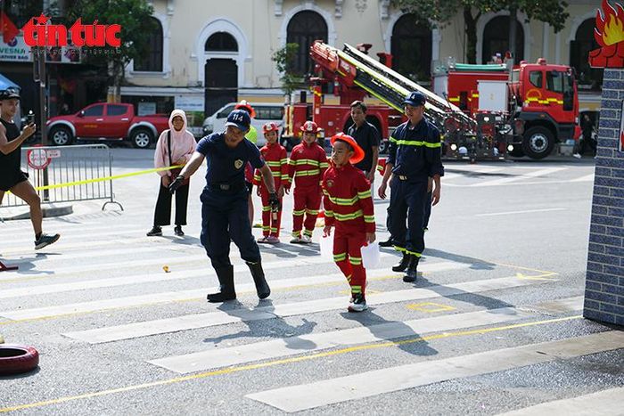 Các em nhỏ trải nghiệm hoạt động chữa cháy, cứu nạn, cứu hộ dưới sự hướng dẫn của cán bộ, chiến sĩ Cảnh sát phòng cháy, chữa cháy và cứu nạn, cứu hộ.