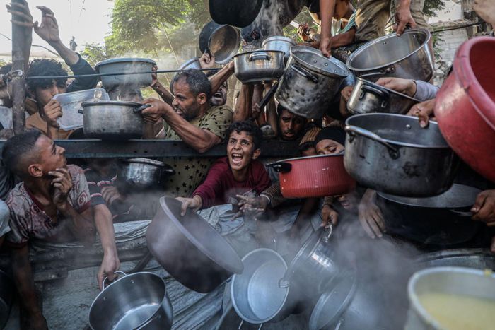 Trẻ em nhận thức ăn cứu trợ tại thành phố Gaza. Ảnh: THX/TTXVN