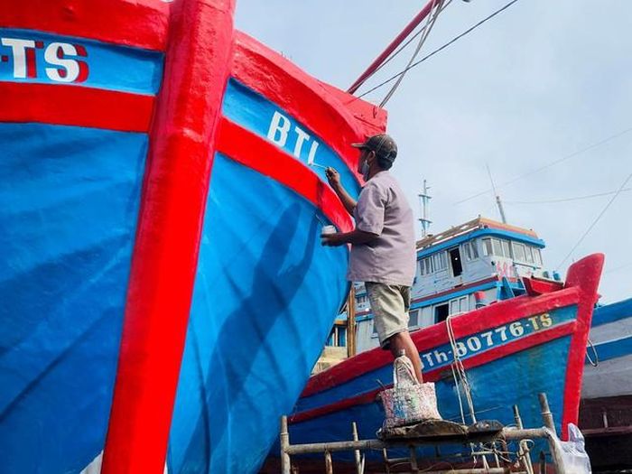 Sơn, vẽ tàu cá ở làng nghề đóng, sửa tàu thuyền Phú Hài (phường Phú Thủy, tỉnh Lâm Đồng).