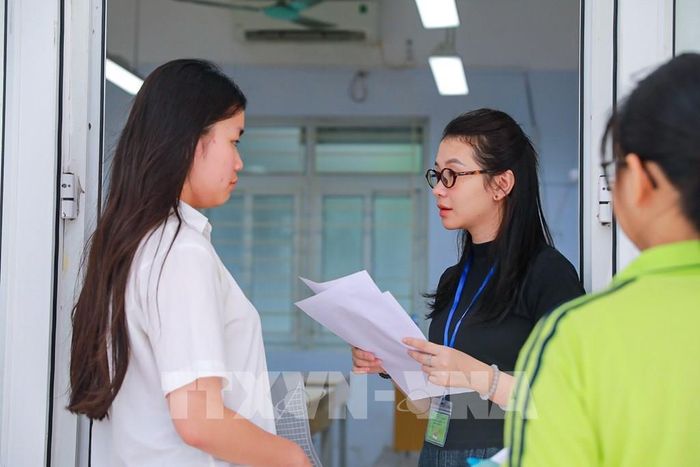 Giám thị kiểm tra thông tin thí sinh trước khi vào phòng thi tại Điểm thi trường THPT Đoàn Kết - Hai Bà Trưng (phường Bạch Mai). Ảnh: Khánh Hòa - TTXVN