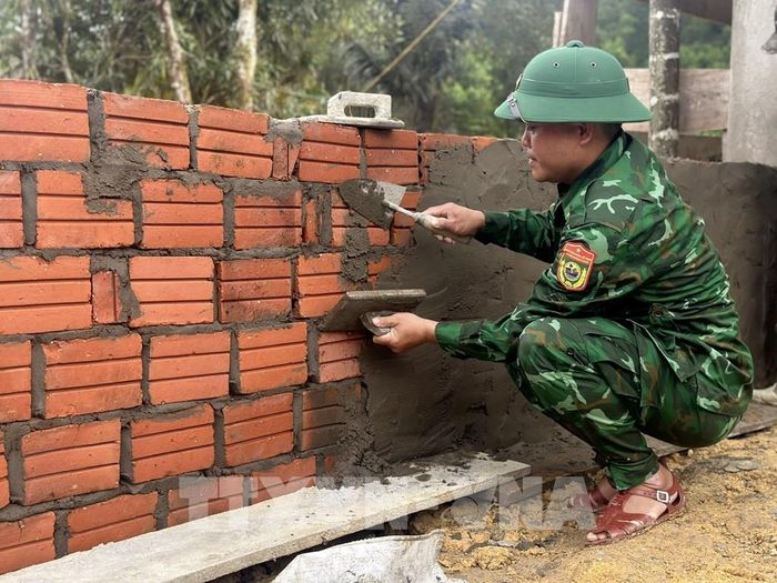 Những "người thợ" không chuyên màu áo lính tích cực hỗ trợ dân xây nhà. Ảnh: Mai Trang - TTXVN