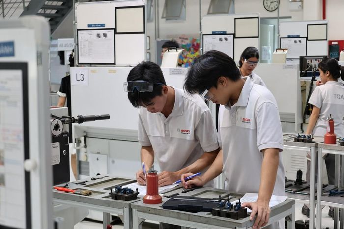 Các học viên tại Trung tâm Đào tạo nghề song hành Bosch TGA thực hành trên máy móc thiết bị hiện đại trong quá trình học tập. Ảnh: Hữu Duyên - TTXVN