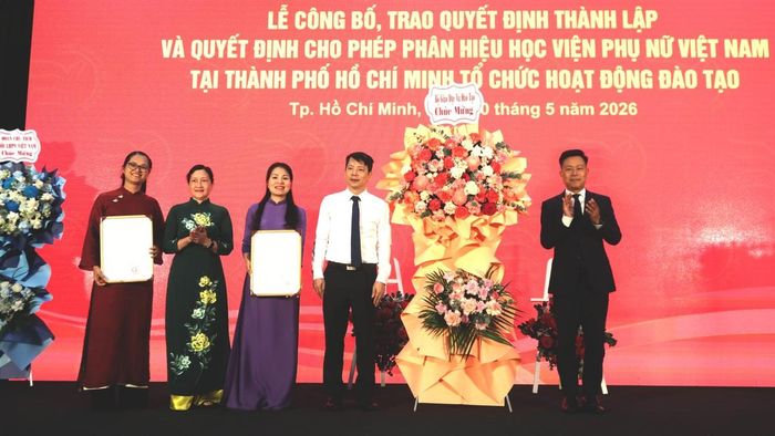 GS.TS Lê Quân, Thứ trưởng Bộ Giáo dục và Đào tạo (bên phải) thực hiện nghi thức trao Quyết định và tặng hoa chúc mừng cho Phân hiệu Học viện Phụ nữ Việt Nam tại TPHCM.