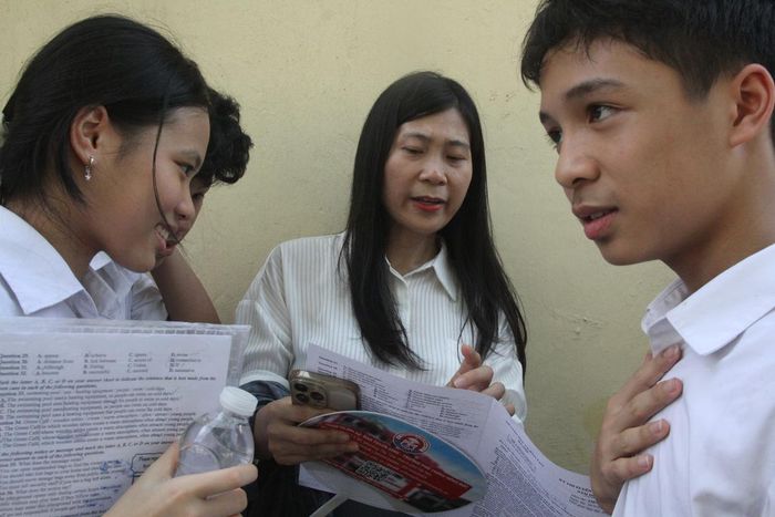 Cô Kim Anh chia sẻ về đề thi môn Tiếng Anh với học sinh tại điểm thi.