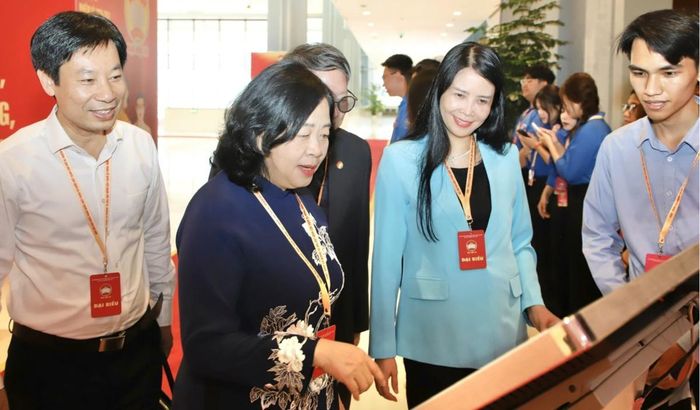 Bà Bùi Thị Minh Hoài (thứ 2 từ trái sang), Ủy viên Bộ Chính trị, Bí thư Trung ương Đảng, Bí thư Đảng ủy MTTQ, các đoàn thể Trung ương, Chủ tịch UBTƯ MTTQ Việt Nam và các đại biểu trải nghiệm không gian triển lãm "Mặt trận số" tại Đại hội đại biểu toàn quốc Mặt trận Tổ quốc Việt Nam lần thứ XI - tháng 5/2026. Ảnh: Thu Hà