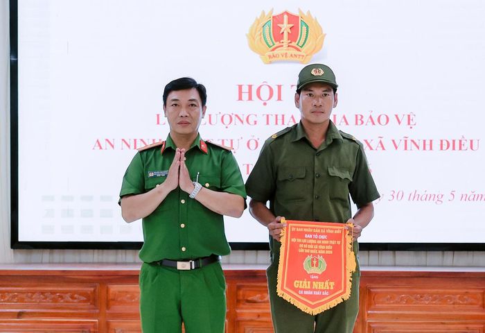 Thiếu tá Nguyễn Văn Cường, Phó trưởng Công an xã Vĩnh Điều trao giải nhất cá nhân cho thí sinh tham gia hội thi.