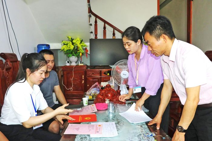  Cán bộ xã Kiên Lao đến hộ gia đình hướng dẫn về dữ liệu đất đai. Ảnh: Hoài Thu 