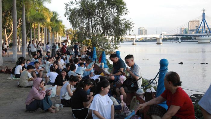 Đông đảo người dân xí chỗ từ sớm ở phía bờ đông sông Hàn để xem màn trình diễn pháo hoa đêm khai mạc. Ảnh: ĐẮC MẠNH