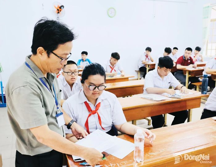 Giám thị điểm thi Trường THPT Ngô Quyền kiểm tra thông tin của thí sinh.