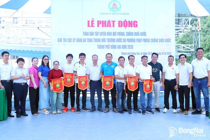 Ban tổ chức, các đại biểu tặng cờ lưu niệm cho các đơn vị tham dự lễ phát động. Ảnh: Huy Anh