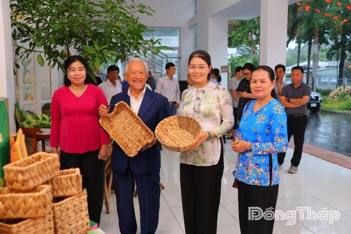 Các đại biểu tham quan, chụp ảnh lưu niệm tại khu trưng bày sản phẩm thủ công, sản phẩm bản địa bên lề Đại hội Cấy Nền miền Nam tại xã Mỹ Thọ.