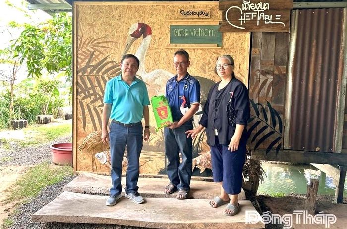 Đồng chí Phan Văn Thắng tặng quà cho gia đình ông Thongpoon, hộ dân sống tại khu vực thả sếu đầu đỏ.