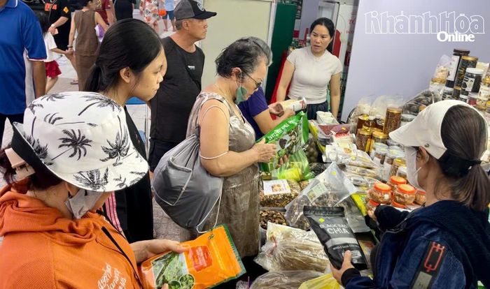 Du khách mua sắm tại gian hàng sản phẩm địa phương.