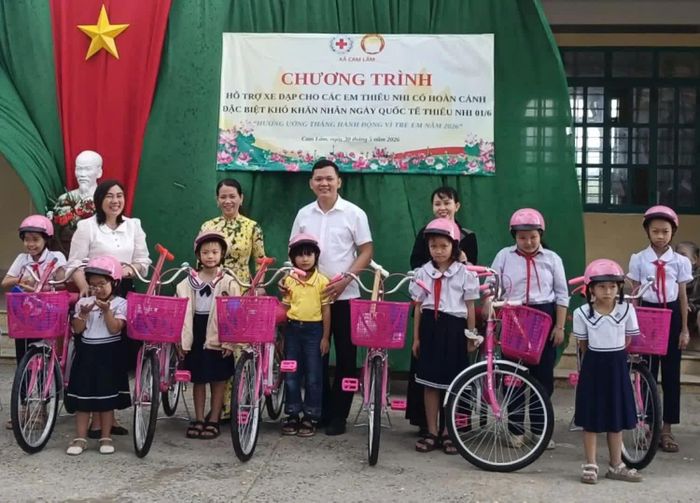 Lãnh đạo Ủy ban MTTQ Việt Nam xã Cam Lâm và Đại diện Công ty Rock Paper Scissors Children’s Fund tặng xe đạp cho học sinh.