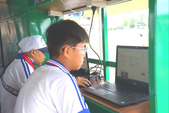 Các em học sinh đọc sách điện tử tại thư viện di động ngay sau lễ khai mạc