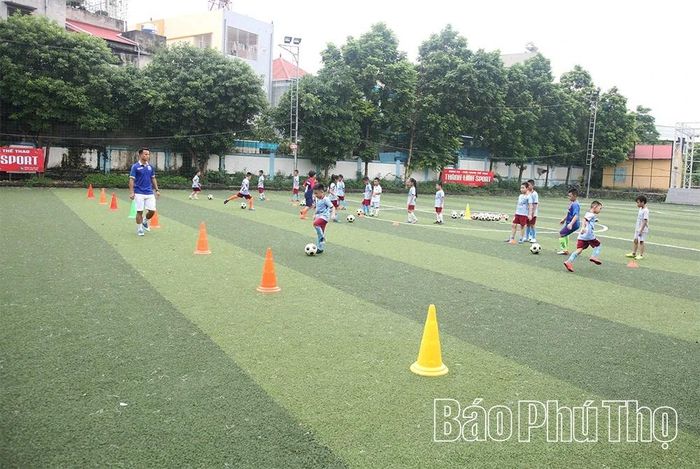 Các em thiếu nhi được hướng dẫn kỹ thuật cơ bản và rèn luyện thể lực trong lớp học bóng đá hè tại sân vận động mini phường Vĩnh Phúc.