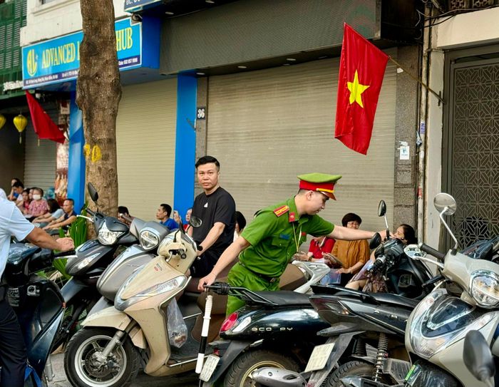 Cán bộ, chiến sĩ công an hướng dẫn, di chuyển phương tiện lên vỉa hè, góp phần bảo đảm giao thông thông suốt, tạo điều kiện thuận lợi cho thí sinh đến điểm thi đúng giờ.