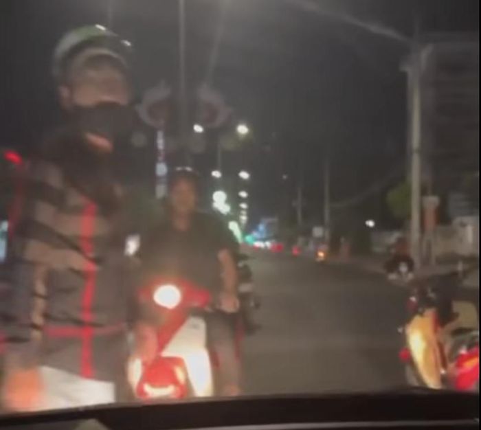 Hình ảnh đối tượng Phát cùng một người đàn ông chặn đầu xe, đập vỡ kính chắn gió. Ảnh cắt từ clip