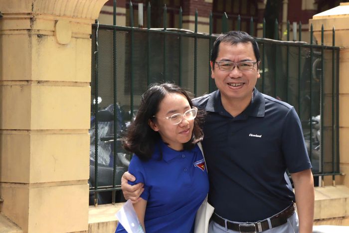 Niềm vui hiện rõ trên gương mặt người cha khi con gái hoàn thành tốt bài thi.