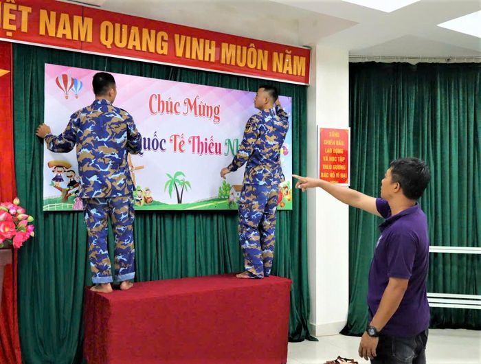Cán bộ, chiến sĩ và đoàn viên thanh niên trên đảo Đá Tây khẩn trương trang trí sân khấu, treo cờ hoa, bóng bay để chuẩn bị cho chương trình vui tết Thiếu nhi 1/6.