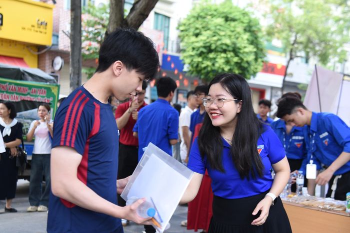 Tình nguyện viên phát bánh, nước hỗ trợ các thí sinh. Ảnh: Xuân Quý