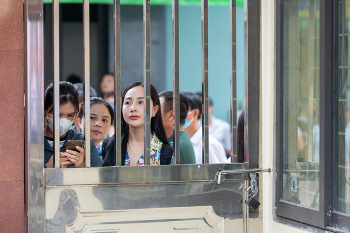 Ánh mắt lo lắng dõi theo bước chân con vào phòng thi. Ảnh: Mạnh Hưng