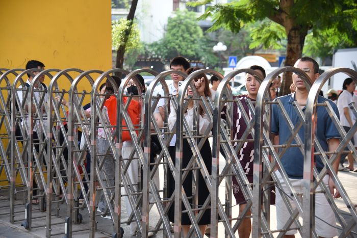 Hiệu lệnh làm bài vang lên, hàng dài phụ huynh vẫn đứng nán lại đợi con. Ảnh: Xuân Quý