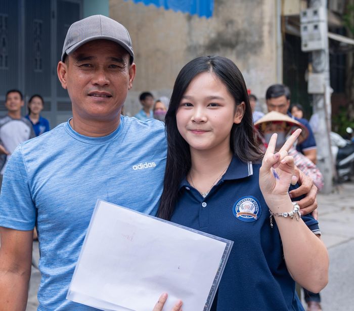 Phụ huynh ôm chầm nữ sinh sau khi hoàn thành môn Ngữ Văn sáng nay. Ảnh: Mạnh Hưng