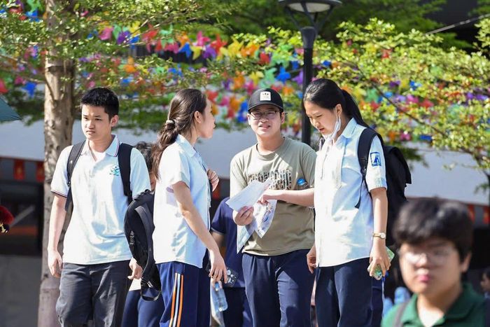 Nhóm thí sinh bàn luận đề thi Ngoại ngữ tại điểm thi Trường THCS Trần Duy Hưng, Phường Yên Hòa. Ảnh: Xuân Quý