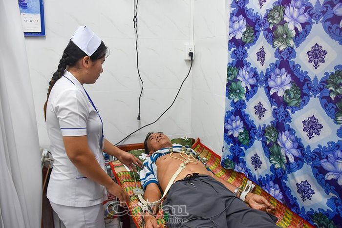 Cán bộ y tế đo điện tim cho người dân.