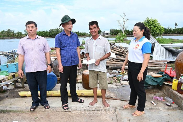 Phó Chủ tịch Ủy ban MTTQ Việt Nam tỉnh Cà Mau Nguyễn Văn Khởi (thứ hai từ trái sang) trao hỗ trợ cho gia đình ông Trịnh Minh Quân (Ấp 14, xã U Minh).