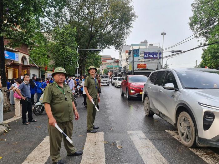 Lực lượng công an, dân phòng phân luồng giao thông trước cổng trường.