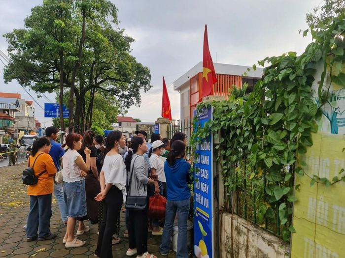 Dù thời tiết có hạt mưa, nhiều phụ huynh vẫn kiên nhẫn đứng chờ ngoài cổng trường, dõi theo con em trong buổi thi đầu tiên của kỳ vào THPT 2026.